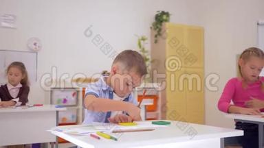 初中时，学生们拿着彩色铅笔，坐在教室里的桌子上，和年轻的老师一起画画